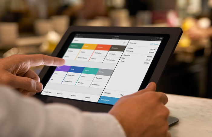 A restaurant employee interacts with Square for Restaurants platform