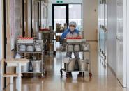 A cook delivers school lunch in front of each classroom at Senju Aoba Junior High School in Tokyo