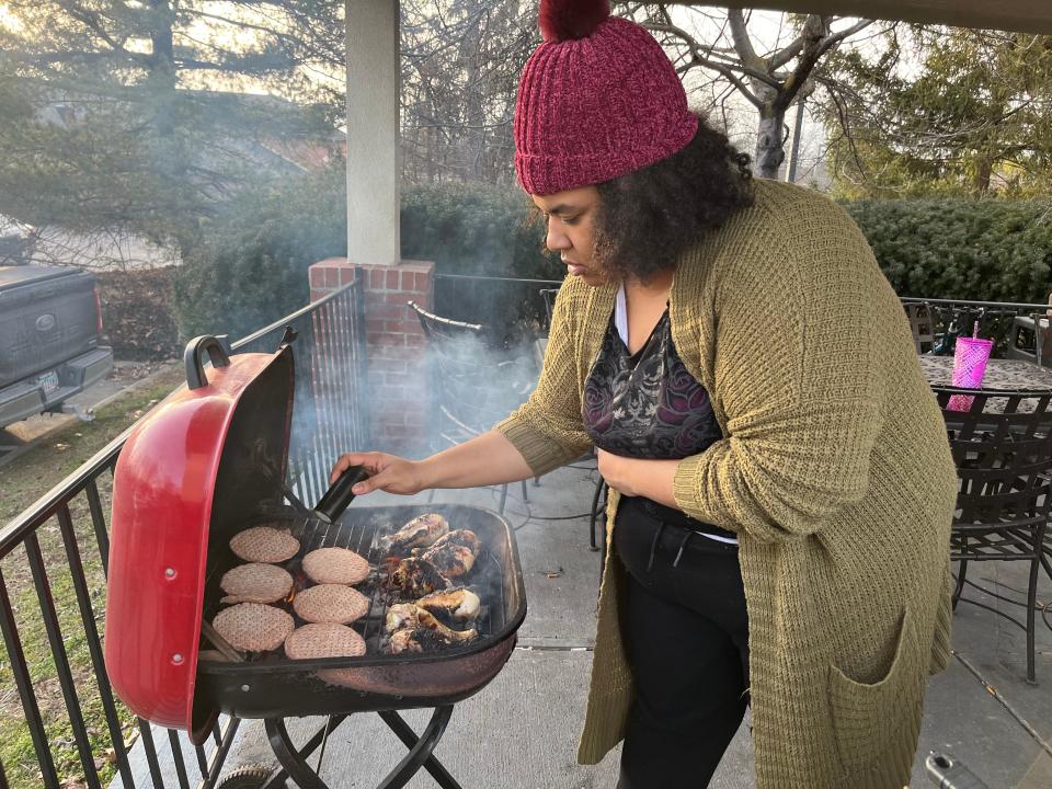 Daisha Harper, 26, seasons meat on a grill at a local motel in February, preparing it for other former Latitude Five25 residents.