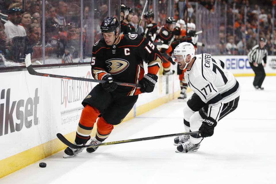Anaheim Ducks’ Ryan Getzlaf, left, moves the puck under pressure by Los Angeles Kings’ Jeff Carter during the second period of an NHL hockey game Friday, March 30, 2018, in Anaheim, Calif. (AP Photo/Jae C. Hong)