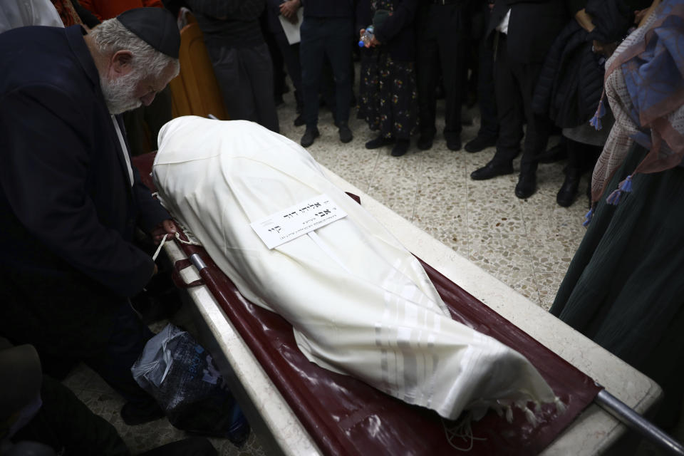 Mourners gather around the body of Eliyahu Kay, a 26-year-old immigrant to Israel from South Africa, during his funeral the day after he was killed when a Palestinian man opened fire in the Old City of Jerusalem, Monday, Nov. 22, 2021, in Jerusalem. (AP Photo/Oded Balilty)