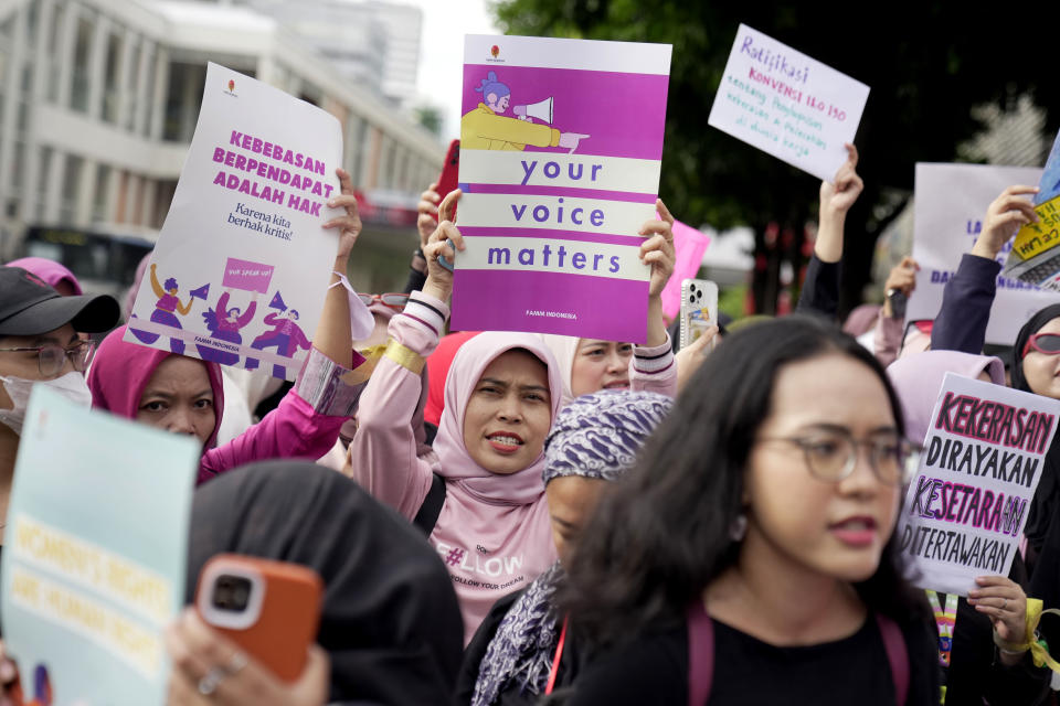 Activistas muestran carteles durante una marcha con motivo del Día Internacional de la Mujer, en Yakarta, Indonesia, el 8 de marzo de 2024. (AP Foto/Dita Alangkara)