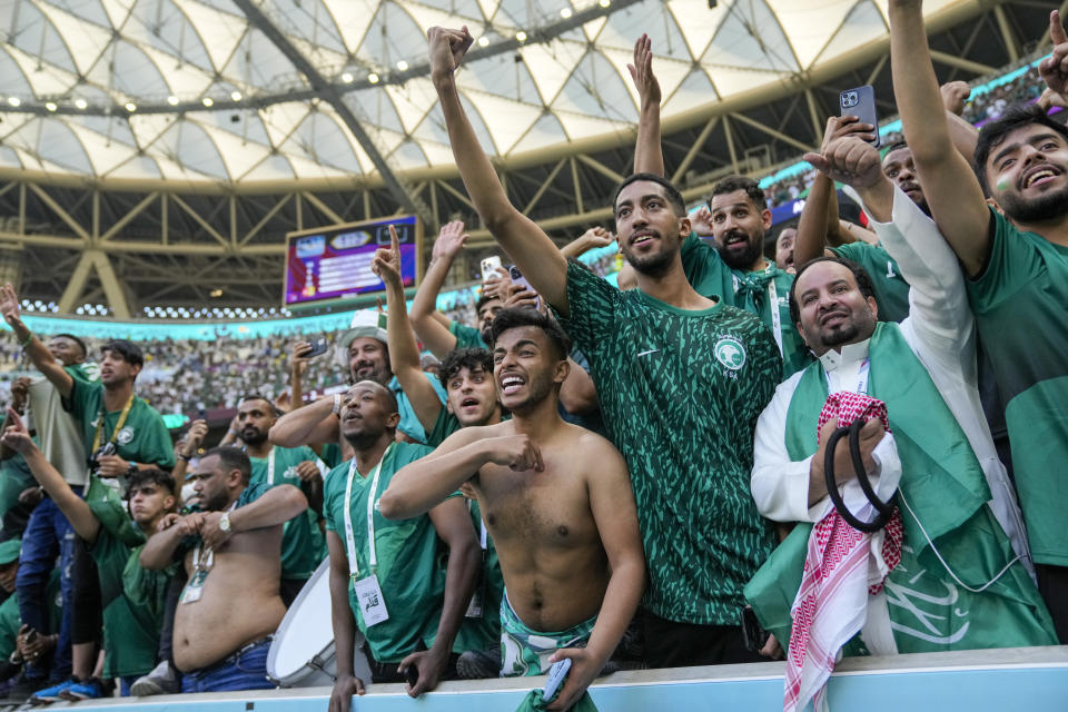 FILE - Saudi Arabia's fans celebrate their victory after the World Cup group C soccer match between Argentina and Saudi Arabia at the Lusail Stadium in Lusail, Qatar, on Nov. 22, 2022. For a brief moment after Saudi Arabia's Salem Aldawsari fired a soccer ball from just inside the penalty box into the back of the net to seal a win against Argentina, Arabs across the divided Middle East found something to celebrate. (AP Photo/Jorge Saenz, File)