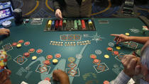 FILE - In this July 23, 2019 file photo, players play at poker tables in the casino at the WinStar World Casino and Resort in Thackerville, Okla. For the last 15 years, casino gambling has been a financial boon for Oklahoma and many of the Native American tribes located there. (AP Photo/Sue Ogrocki, File)