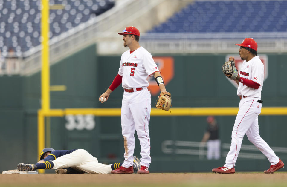 Rutgers' Danny DiGeorgio (5) and Garrett Callaghan, right, react after Michigan's Ted Burton, left, safely stole second base ahead of a tag by DiGeorgio in the fourth inning of the NCAA college Big Ten baseball championship game Sunday, May 29, 2022, at Charles Schwalb Field in Omaha, Neb. (AP Photo/Rebecca S. Gratz)