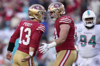 San Francisco 49ers quarterback Brock Purdy (13) celebrates after throwing a touchdown pass to running back Christian McCaffrey with offensive tackle Daniel Brunskill, middle, as Miami Dolphins defensive tackle Christian Wilkins (94) reacts during the first half of an NFL football game in Santa Clara, Calif., Sunday, Dec. 4, 2022. (AP Photo/Godofredo A. Vásquez)