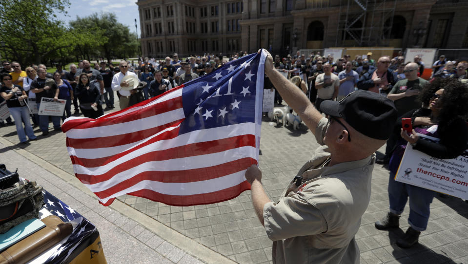 <p>A man holds a 3% flag as a group recited the pledge during a pro gun-rights rally at the state capitol, Saturday, April 14, 2018, in Austin, Texas. (Photo: Eric Gay/AP) </p>