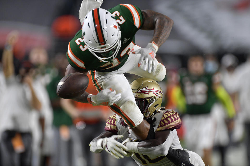 Miami running back Cam'Ron Harris loses the ball out of bounds while trying to jump over Florida State defensive back Travis Jay during the first half of an NCAA college football game Saturday, Sept. 26, 2020, in Miami Gardens, Fla. (Michael Laughlin/South Florida Sun-Sentinel via AP)