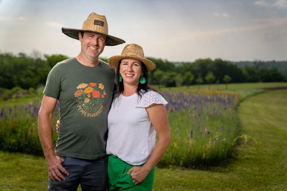 Adam and Jenn O'Neal stand for a photo at their flower farm PepperHarrow in Winterset. The farm has been rebuilt after a tornado tore through last year.