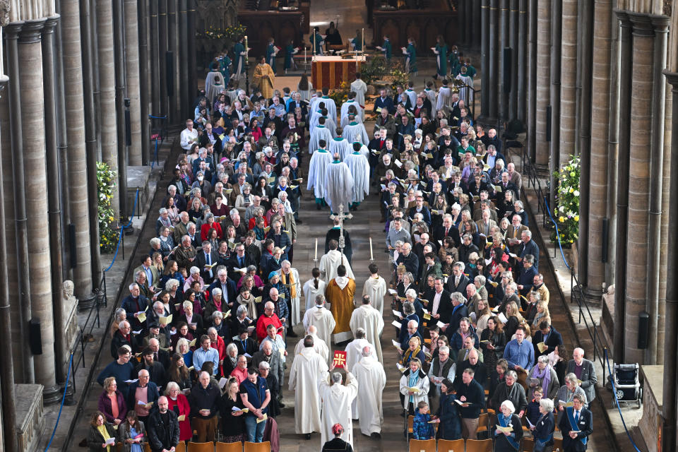 SALISBURY, ENGLAND - APRIL 09: A packed congregation as clergy process down the aisle for the Easter Sunday morning service, at Salisbury Cathedral on April 09, 2023 in Salisbury, England. The Easter Liturgy and lighting of the Paschal candle is held every year at Easter, and is used throughout the Paschal season and then throughout the year on special occasions, such as baptisms and funerals. The lighting of the Paschal candle from the new fire, in the half-light early on Easter morning, represents resurrection and new life. The single candle is carried into the Cathedral and the proclamation of the Light of Christ fills the whole space. The light is spread round the Cathedral with candles held by all the baptised. (Photo by Finnbarr Webster/Getty Images)