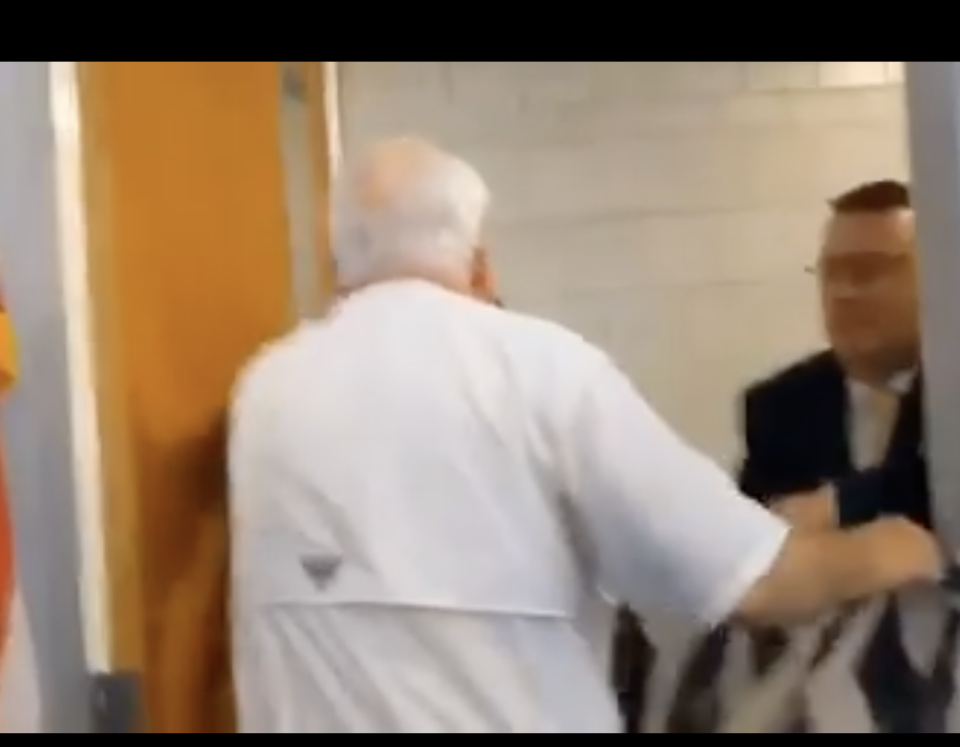 This video screenshot shows a confrontation between Line 5 protesters and NCMC officials at the Enbridge Luncheon Lecture on June 22, 2023. At the right of the image appears to be North Central Michigan College President David Roland Finley.