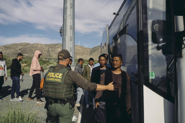 A group of migrants board a bus that will transport them to a Customs and Border Protection processing center in Jacumba, Calif., on May 15, 2023. (Mark Abramson/The New York Times)