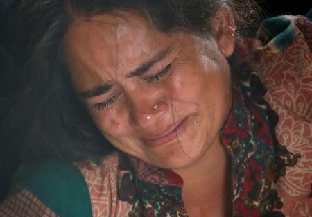 A family member cries as the bodies (unseen) of Nepali nationals, killed when a suicide bomber struck a minibus in Kabul, are lined up after being flown from Afghanistan at Tribhuvan International Airport in Kathmandu, Nepal June 22, 2016. REUTERS/Navesh Chitrakar