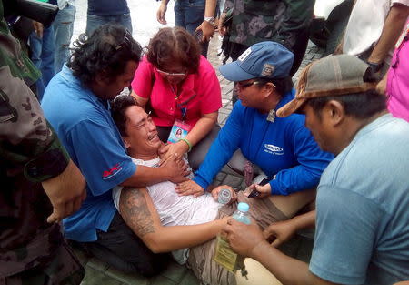 Rescuers try to calm a passenger who said his pregnant wife and two children are still missing after the MBCA Kim-Nirvana ferry capsized in Ormoc city, central Philippines July 2, 2015. REUTERS/Mitzi Llanes