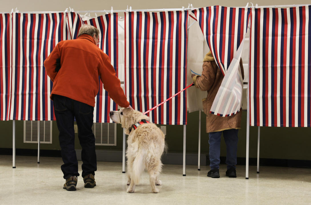 A dog accompanies its owner to vote at Christ the King Parish in Concord, N.H., on Tuesday.