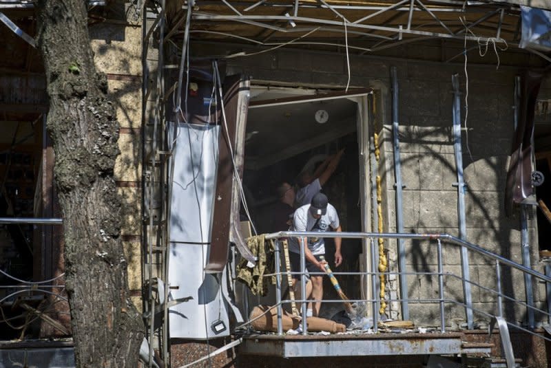 People clean debris at the site of a glide bomb attack on a residential building in Kharkiv, northeastern Ukraine on Saturday. Photo b Sergey Kozlov/EPA-EFE