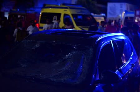 People look on at the damage left by a fire from a blast outside the National Cancer Institute, Cairo