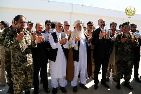 Afghanistan's President Ashraf Ghani (3rd L) prays for the victims of April 21's attack on an army headquarters during his visits in Mazar-i-Sharif, northern Afghanistan April 22, 2017. Presidential Palace /Handout via REUTERS