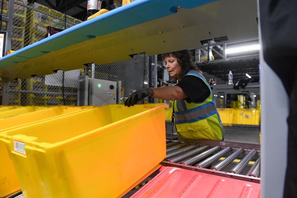 Marie Steele moves bins for a picker to fill inside the new Amazon Fulfillment Center on Thursday, October 13, 2022, in Sioux Falls.