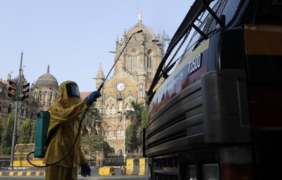 A civic worker sanitizes the area outside Chhatrapati Shivaji terminus railway station during a lockdown to control the spread of the coronavirus in Mumbai, India, Thursday, April 2, 2020. India's 21-day lockdown has effectively kept 1.3 billion people at home for all but essential trips to places like markets or pharmacies. The steps were taken after a nationwide lockdown announced last week by Prime Minister Narendra Modi led to a mass exodus of migrant workers from cities to their villages, often on foot and without food and water, raising fears that the virus may have reached to the countryside, where health care facilities are limited. (AP Photo/Rajanish Kakade)