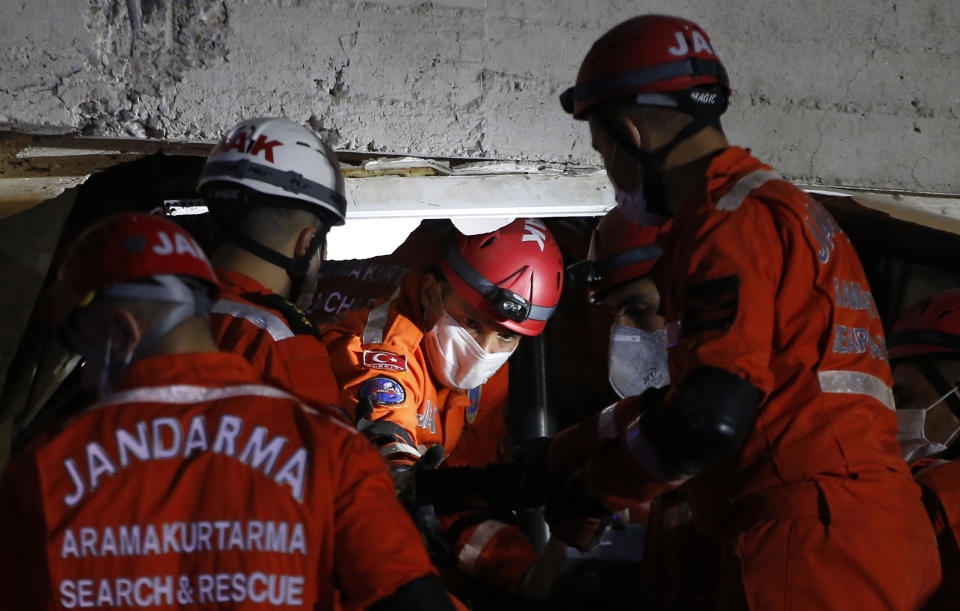 Members of rescue services search in the debris of a collapsed building for survivors in Izmir, Turkey, early Saturday, Oct. 31, 2020. A strong earthquake struck Friday in the Aegean Sea between the Turkish coast and the Greek island of Samos, killing several people and injuring hundreds amid collapsed buildings and flooding. (AP Photo/Emrah Gurel)