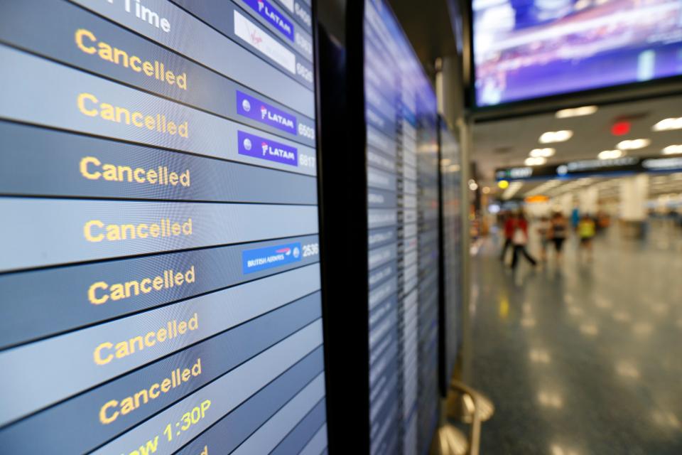 A monitor lists cancelled flights at Miami International Airport in September 2017.