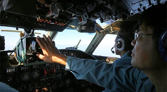 A cabin crew of the Vietnam Air Force is seen onboard a flying AN-26 Soviet made aircraft during a search operation for the missing Malaysia Airlines flight MH370 plane over the southern sea between Vietnam and Malaysia. Photo: AP.