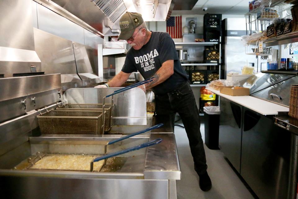 Grant Bergeron, longtime Gilley's Diner employee, makes burgers, hot dogs and fries for customers in Portsmouth on Wednesday, May 25, 2022.