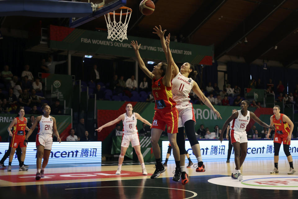 Natalie Achonwa of Canada center right, throws the ball at the basket next to Queralt Casas of Spain during the womens' basketball Olympic qualifying tournament second round match Canada vs Spain in Sopron, Hungary, Friday, Feb. 9, 2024. (Zsombor Toth/MTI via AP)