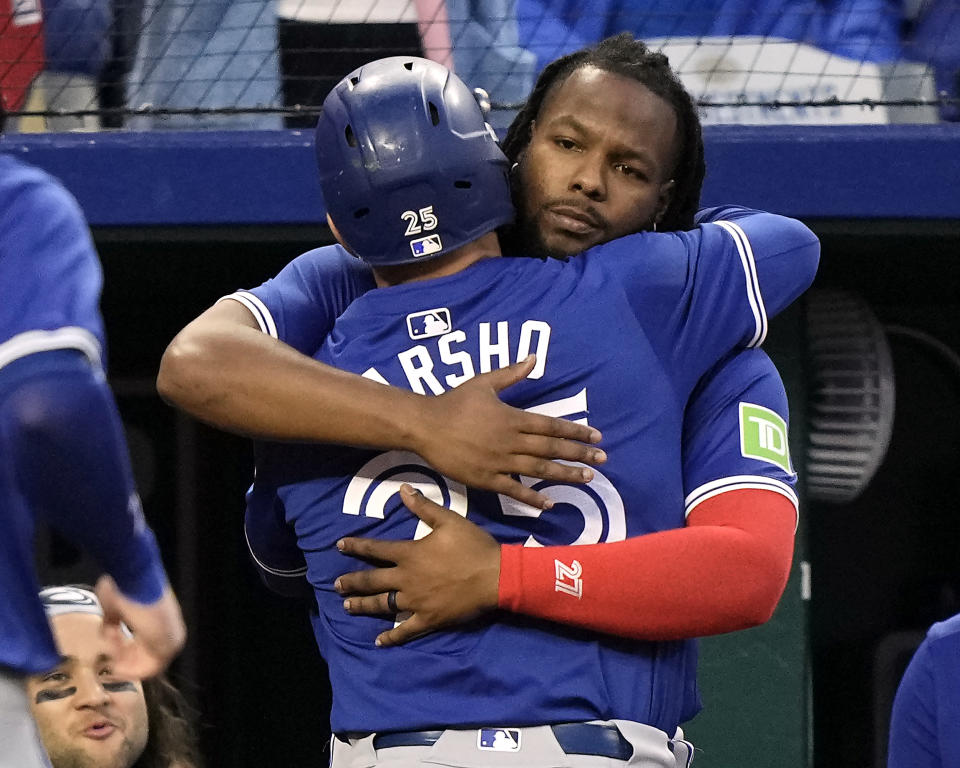 Toronto Blue Jays' Daulton Varsho (25) celebrates with Vladimir Guerrero Jr. after hitting a two-run home run during the sixth inning of a baseball game against the Kansas City Royals Monday, April 22, 2024, in Kansas City, Mo. (AP Photo/Charlie Riedel)