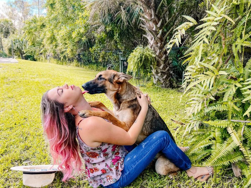 Liz Scott of Naples embraces her dog Harley after being reunited Tuesday. The German Shepherd went missing during hurricane clean-up last week but showed up again three days later at her back door.