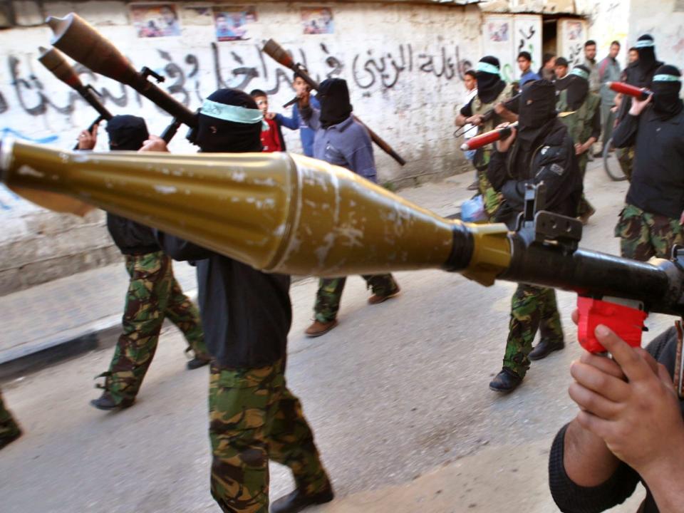 Palestinian militants march with their weapons in Khan Younis refugee camp south of the Gaza Strip March 27, 2005.