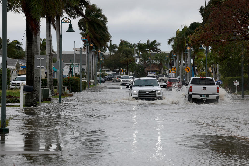 FORT PIERCE, FLORIDA - NOVEMBER 10: Vehicles drive through a flooded street after Hurricane Nicole came ashore on November 10, 2022 in Fort Pierce, Florida. Nicole came ashore as a Category 1 hurricane before hitting Florida’s east coast. (Photo by Joe Raedle/Getty Images)