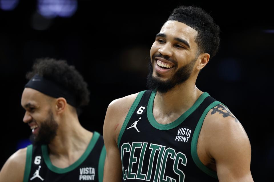 Boston Celtics' Jayson Tatum, right, and Derrick White react during the first half of the team's NBA basketball game against the Toronto Raptors, Friday, April 7, 2023, in Boston. (AP Photo/Michael Dwyer)