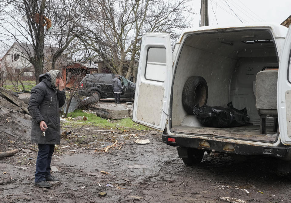 A relative cries as a body of a civilian killed in a Russian air raid at the beginning of the Russia-Ukraine war, was loaded on a van in Borodyanka close to Kyiv, Ukraine, Saturday, Apr. 9, 2022. Borodyanka was occupied by the Russian troops and freed in a month by the Ukrainian army, which allowed emergency workers to search civilian bodies under the ruins. (AP Photo/Efrem Lukatsky)