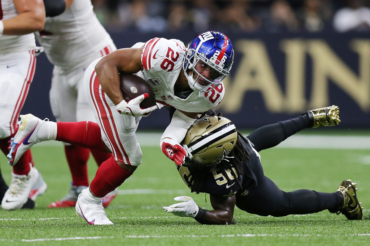 NEW ORLEANS, LOUISIANA - OCTOBER 03: Saquon Barkley #26 of the New York Giants is tackled by Demario Davis #56 of the New Orleans Saints during the first quarter at Caesars Superdome on October 03, 2021 in New Orleans, Louisiana. (Photo by Jonathan Bachman/Getty Images)