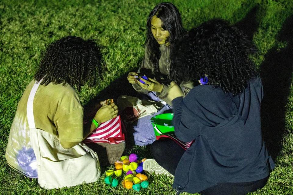 Jessica Fung, de 16 años, Kaylee Aleu, de 16 años, y Genesis Pinales, de 16 años, miran sus huevos de Pascua de un lanzamiento de huevos desde un helicóptero después de un servicio de adoración de los estudiantes de CF en la iglesia Christ Fellowship en Palmetto Bay, Florida, el viernes 8 de abril de 2022.