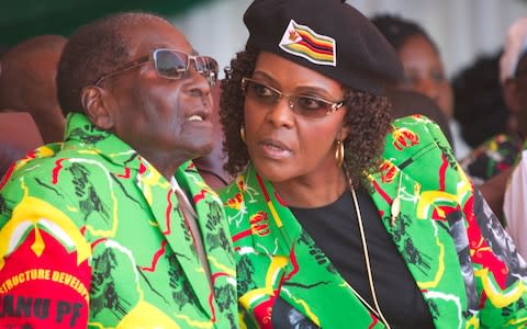 Zimbabwean President Robert Mugabe and his wife Grace follow proceedings during a youth rally in Marondera Zimbabwe - Credit: Tsvangirayi Mukwazhi/AP