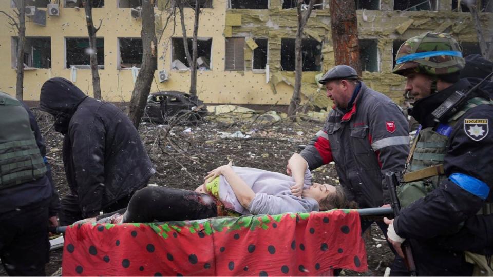 Ukrainian emergency workers and volunteers carry an injured pregnant woman from a maternity hospital damaged by an airstrike in Mariupol. This footage appeared in ‘20 Days in Mariupol’ (AP)