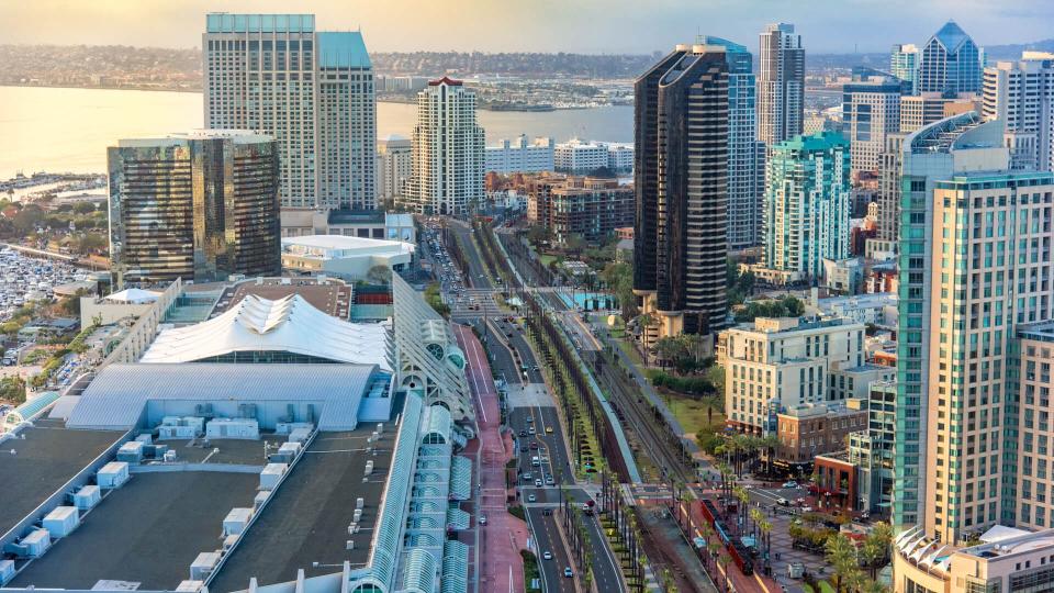 Aerial view of Harbor Drive flanked by highrise hotels and condominiums to the right and the San Diego Convention Center, home to Comic Con, to the left.