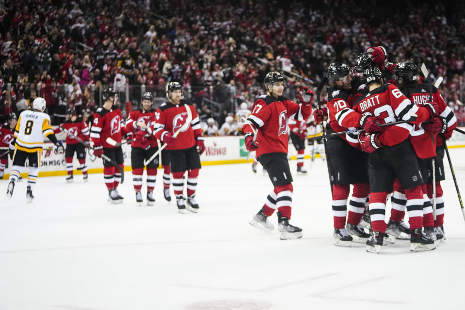 The New Jersey Devils celebrate after Dougie Hamilton scored the game-winning goal during the overtime period of an NHL hockey game against the Pittsburgh Penguins, Sunday, Jan. 22, 2023, in Newark, N.J. The Devils won 2-1 in overtime. (AP Photo/Frank Franklin II)