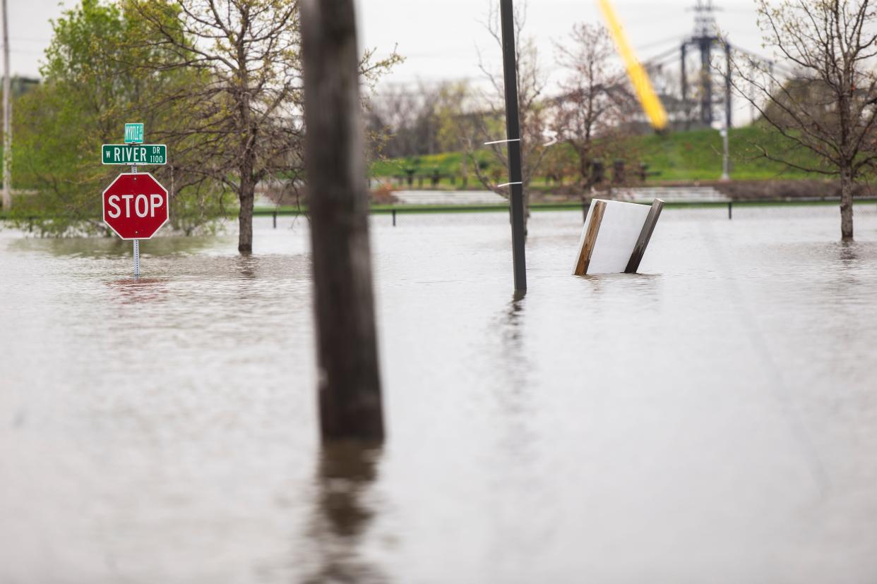 Water surrounds a stop sign in Davenport after water from the Mississippi River broke through temporary flood barriers, in 2019. The river is flooding again.