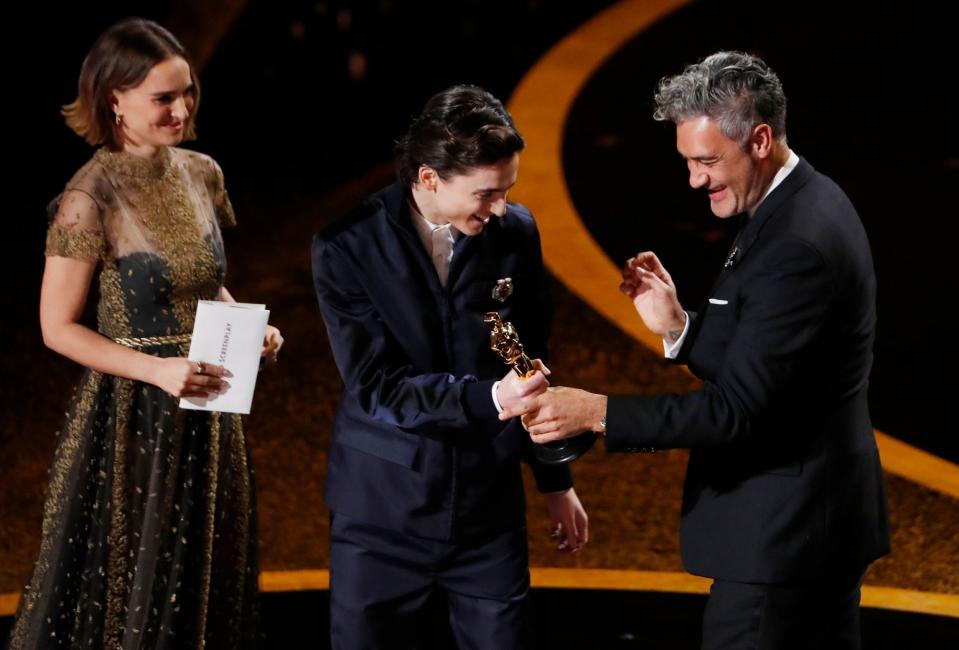 Taika Waititi accepts the award for Best Adapted Screenplay for 'Jojo Rabbit' from Timothee Chalamet and Natalie Portman at the 92nd Academy Awards (Reuters)