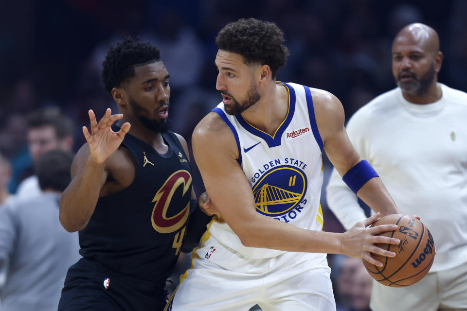 Golden State Warriors guard Klay Thompson (11) plays against Cleveland Cavaliers guard Donovan Mitchell, left, during the first half of an NBA basketball game, Sunday, Nov. 5, 2023, in Cleveland. (AP Photo/Ron Schwane)