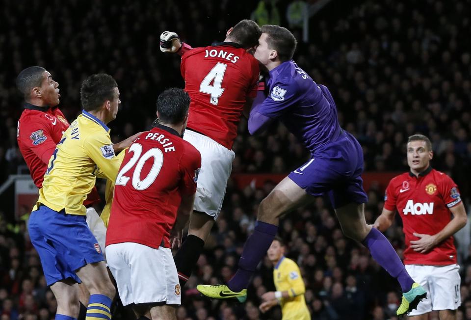 Manchester United's Phil Jones clashes heads with Arsenal's Wojciech Szczesny (2nd R) during their English Premier League soccer match at Old Trafford in Manchester, northern England, November 10, 2013.
