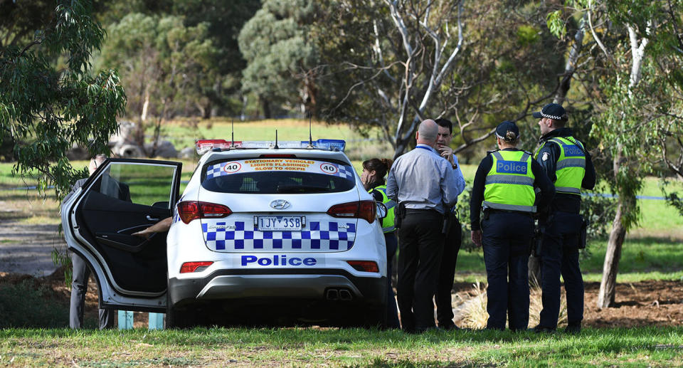 Police gather at Royal Park, Parkville, where a woman was found dead on Saturday morning.