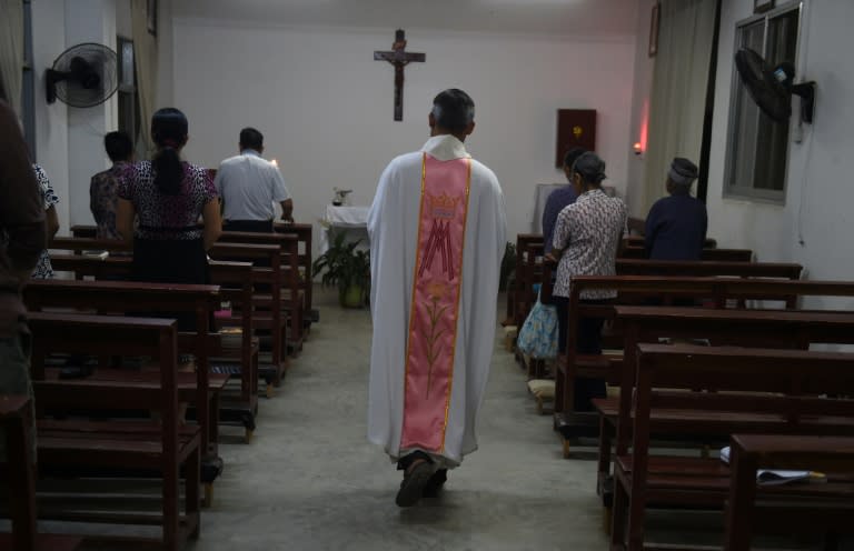 A priest starts Mass at the Catholic church in Dingan, China's southern Guangxi region