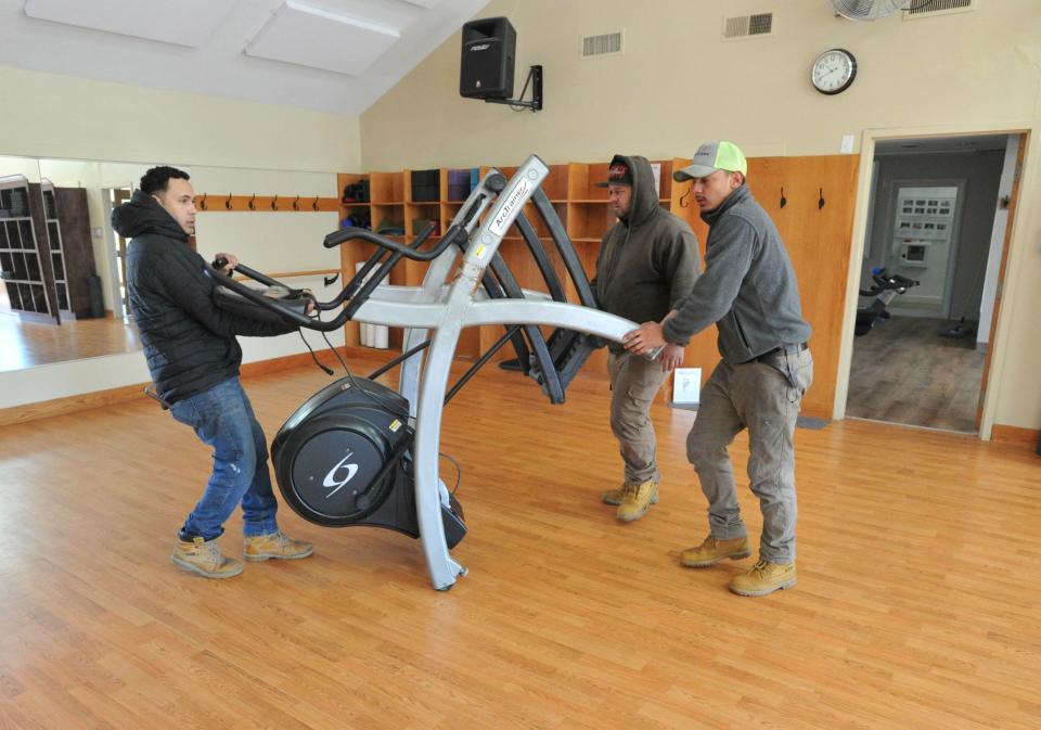 Workmen remove fitness equipment from Webb's Pro Fitness in Norwell that has closed after 46 years, Thursday, March 30, 2023.