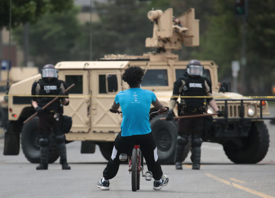 A man rides a bicycle up to a law enforcement checkpoint Friday in Minneapolis. (Photo: Scott Olson/Getty Images)