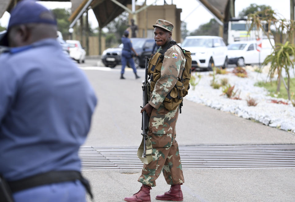 A soldier guards the entrance, Friday, March 13, 2020, to the venue where repatriated South Africans from Wuhan China will be held in quarantine near Polokwane, South Africa. For most people the new coronavirus causes only mild or moderate symptoms, such as fever and cough. For some, especially older adults and people with existing health problems, it can cause more severe illness, including pneumonia. (AP Photo)